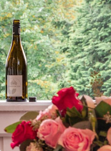 a bottle of wine sitting on a window sill with roses at Gut Moorbeck in Amelhausen