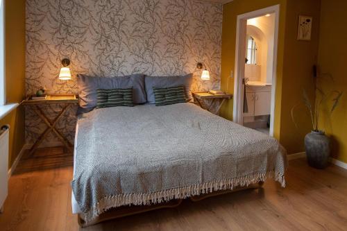 a bedroom with a bed with two lamps on two tables at GÆSTEHUSET in Tarm