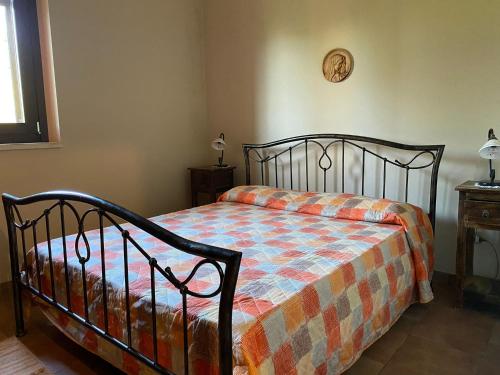 een slaapkamer met een bed met een oranje en blauwe deken bij Casa Trachini in Palmi