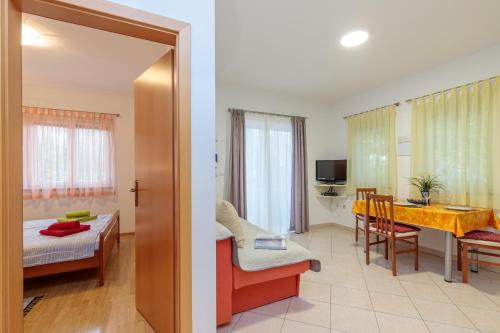 a hotel room with a bed and a dining room at Apartments Alen in Fažana