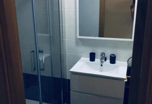 łazienka z umywalką i prysznicem z lustrem w obiekcie Lux Apartm Beauvivir w mieście Torre del Mar
