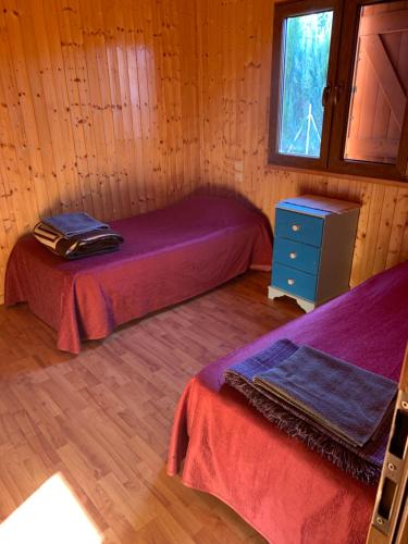 a room with two beds in a wooden cabin at casa peninsula caspe 2 in Caspe