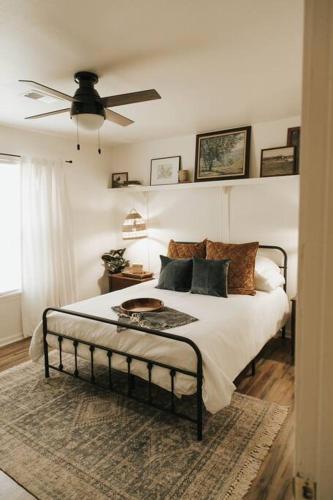 a bedroom with a bed and a ceiling fan at The Woodlawn Guest Cottage in Hot Springs