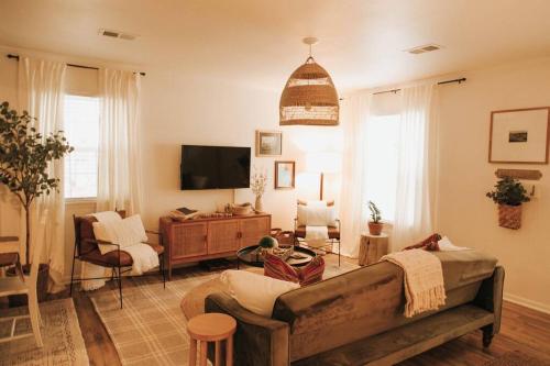 un salon avec un canapé et une télévision dans l'établissement The Woodlawn Guest Cottage, à Hot Springs