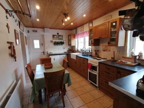 a kitchen with a table and chairs in a room at Carnowen Cottage in Ringsend