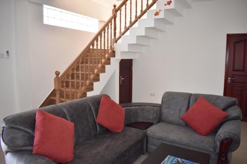 ein Wohnzimmer mit einem Sofa und einer Treppe in der Unterkunft Dawn Self-Catering in Anse aux Pins