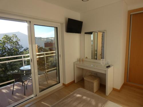 a room with a mirror and a table and a balcony at Villa Barrinha in Praia de Mira