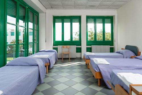 a row of beds in a room with windows at Villaggio Torre Marina in Marina di Massa