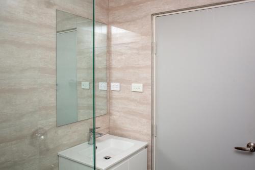y baño con lavabo y espejo. en Five Island Hotel en Cringila