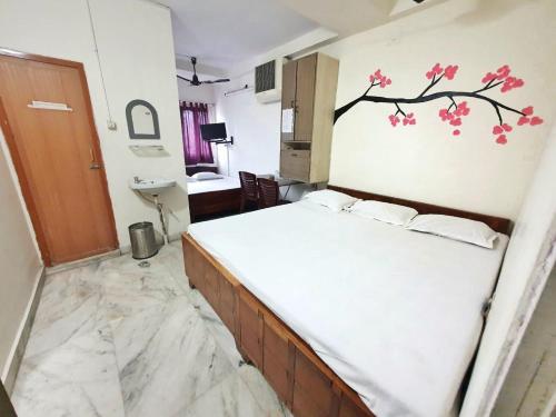 a bedroom with a bed with a tree mural on the wall at Georgian Inn in Kolkata