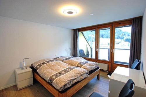 ein Schlafzimmer mit einem Bett und einem großen Fenster in der Unterkunft Touring 401 in Davos