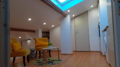 a room with two chairs and a table and a skylight at Appartement Le Bonheur in Pibrac