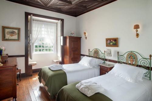 a bedroom with two beds and a window at Casa do Salgueiral in Santa Marta de Penaguião