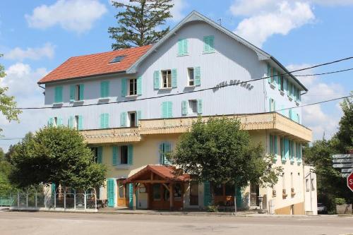 a large white building with a red roof at Hôtel Restaurant des Lacs in Chaux-des-Crotenay