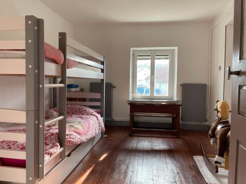 une chambre avec deux lits superposés et un bureau dans l'établissement Maison de campagne proche Lac de Bouzey, à Chaumousey