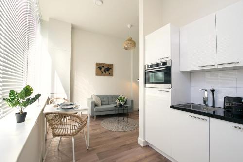 a kitchen and living room with a table and a couch at Boutique Scheveningen beach apartment in Scheveningen