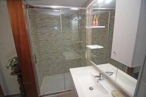 a bathroom with a glass shower and a sink at Casa das Laranjeiras in Carvalheira