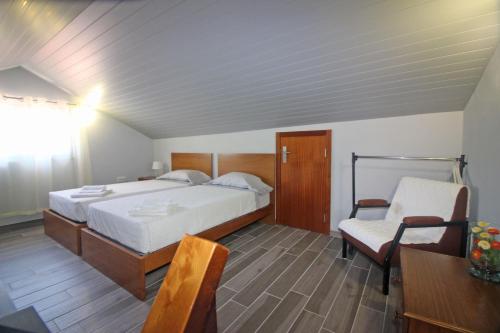 ein Schlafzimmer mit einem Bett, einem Tisch und einem Stuhl in der Unterkunft Casa das Laranjeiras by Gerês Casas in Carvalheira