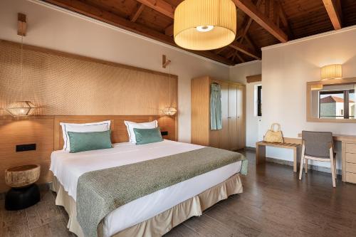 a bedroom with a large bed and a desk at Caldera Platanias Villas in Plataniás