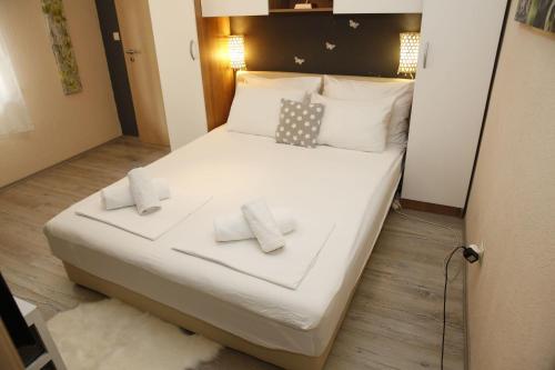 a bed in a small room with two pillows on it at Apartment Tina in Vodice