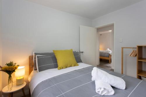 a bedroom with a blue bed with a yellow pillow at Black Swan Vista in North Fremantle