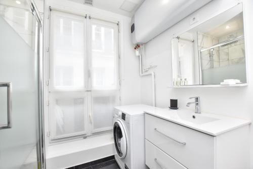La salle de bains blanche est pourvue d'un lavabo et d'un lave-linge. dans l'établissement Cozy apartment 2BR-6P - Royal Palace-Lo Museum, à Paris