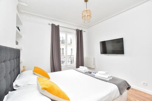 une chambre avec un lit blanc et une télévision dans l'établissement Cozy apartment 2BR-6P - Royal Palace-Lo Museum, à Paris