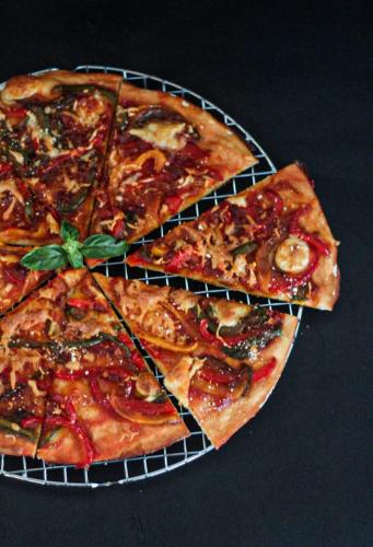 a pizza on a rack with four slices missing at BeSS Mansion Hotel Surabaya in Wonocolo