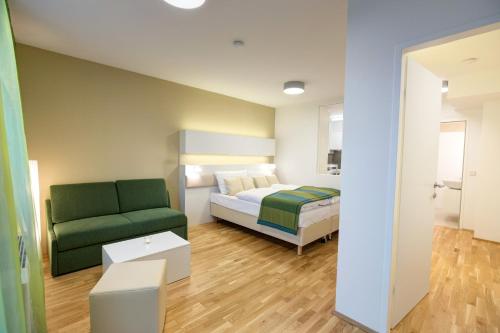 um quarto com uma cama e um sofá verde em Smart Apart Living - Wien Hauptbahnhof - self check-in em Viena