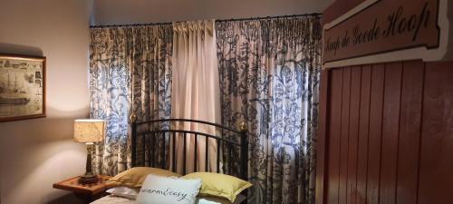 a bedroom with a bed and a window with curtains at MyAula in Tierpoort