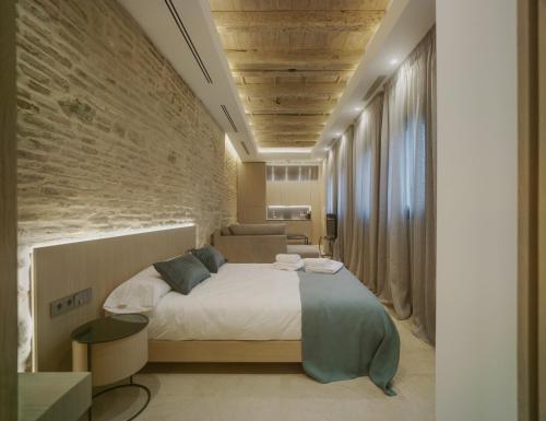 a bedroom with a bed and a brick wall at Apartamentos Los Patios del Pañuelo in Córdoba