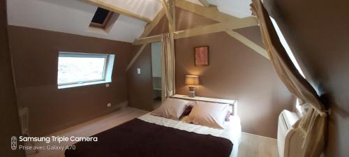 1 dormitorio con cama con dosel y ventana en CHAMBRES D'HOTES SERMUS, en Vézac