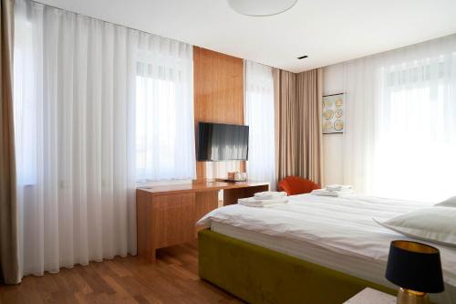 a hotel room with a bed and a television at Hotel Glory in Oradea
