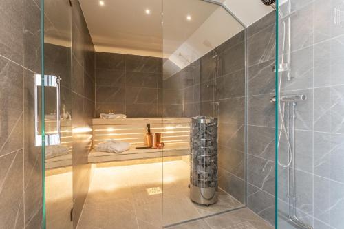 uma casa de banho com um chuveiro e uma porta de vidro em Hotell Drottninggatan 11 em Boden
