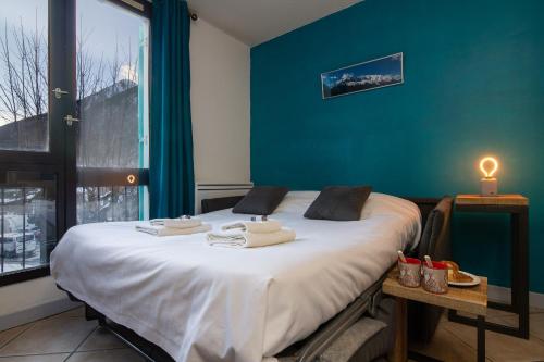 - une chambre dotée d'un lit avec un mur bleu dans l'établissement Chamonix Sud - Balme 111 - Happy Rentals, à Chamonix-Mont-Blanc