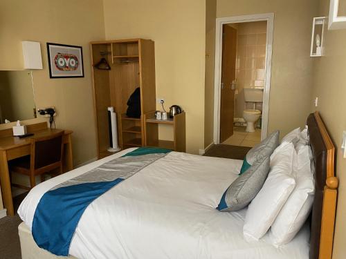 a bedroom with a large bed and a bathroom at Cardiff Sandringham Hotel in Cardiff