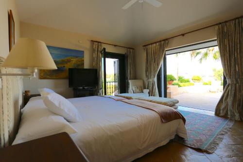a bedroom with a large white bed and a sliding glass door at Las Ranas CASASOLA BEACH & GOLF VILLA in Estepona