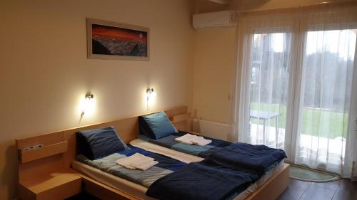 1 dormitorio con 2 camas y ventana grande en Búzavirág Apartmanház en Balatonakali