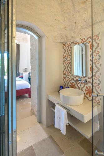 a bathroom with a sink and a mirror at Borgo dei Lecci Puglia in Selva di Fasano