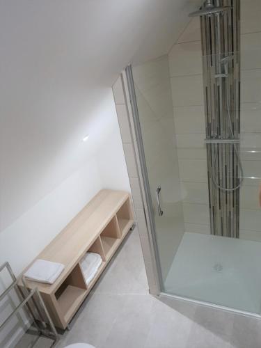 La salle de bains est pourvue d'une douche et d'une cabine de douche en verre. dans l'établissement Superbe appartement type T1 proche Strasbourg, à Truchtersheim