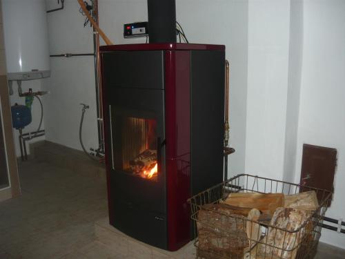 a fireplace with a fire in it in a room at Chalupa Erika in Dobšín