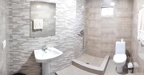 a white bathroom with a sink and a toilet at Guest House Gelit in Mtskheta