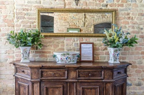 two vases on top of a wooden dresser with a mirror at Villa Ca de Poi - Tabiano Castle Country Villas in Salsomaggiore Terme