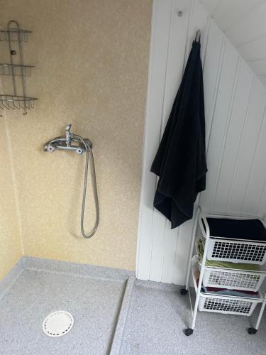a shower with a black umbrella hanging on a wall at Centrum lejlighed in Viborg