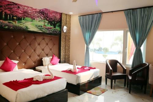 a hotel room with two beds and a window at Blue Diamond Resort & Hotel in Muzaffarpur