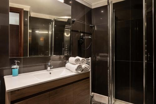 a bathroom with a sink and a shower with towels at Caldera Platanias Villas in Plataniás
