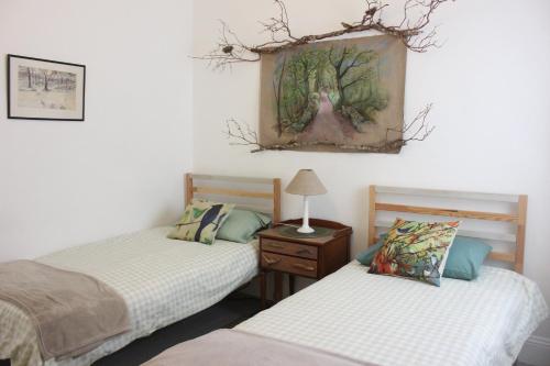 een slaapkamer met 2 bedden en een schilderij aan de muur bij Johnston House: Historic Village Retreat in Kinvara