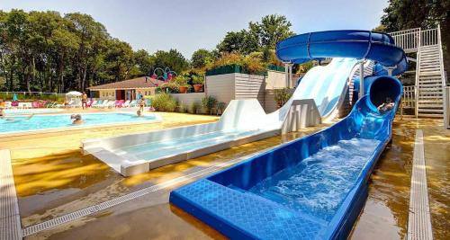 a water slide in a pool with a child on it at HOME-COSY - 6 pers - 40 m2 3 CH - 2 SDB et 2 WC in Saint-Brevin-les-Pins