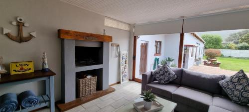 a living room with a couch and a fireplace at Normandie On Sea in Hermanus