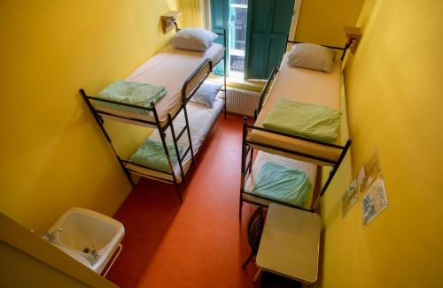 a room with three bunk beds and a toilet at Strowis Hostel in Utrecht